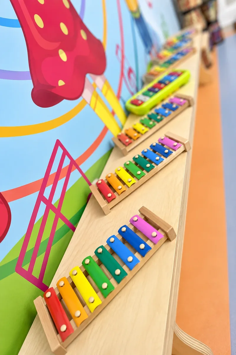 Duvarda sıralanmış renkli çocuk ksilofonları ve vurmalı çalgılar